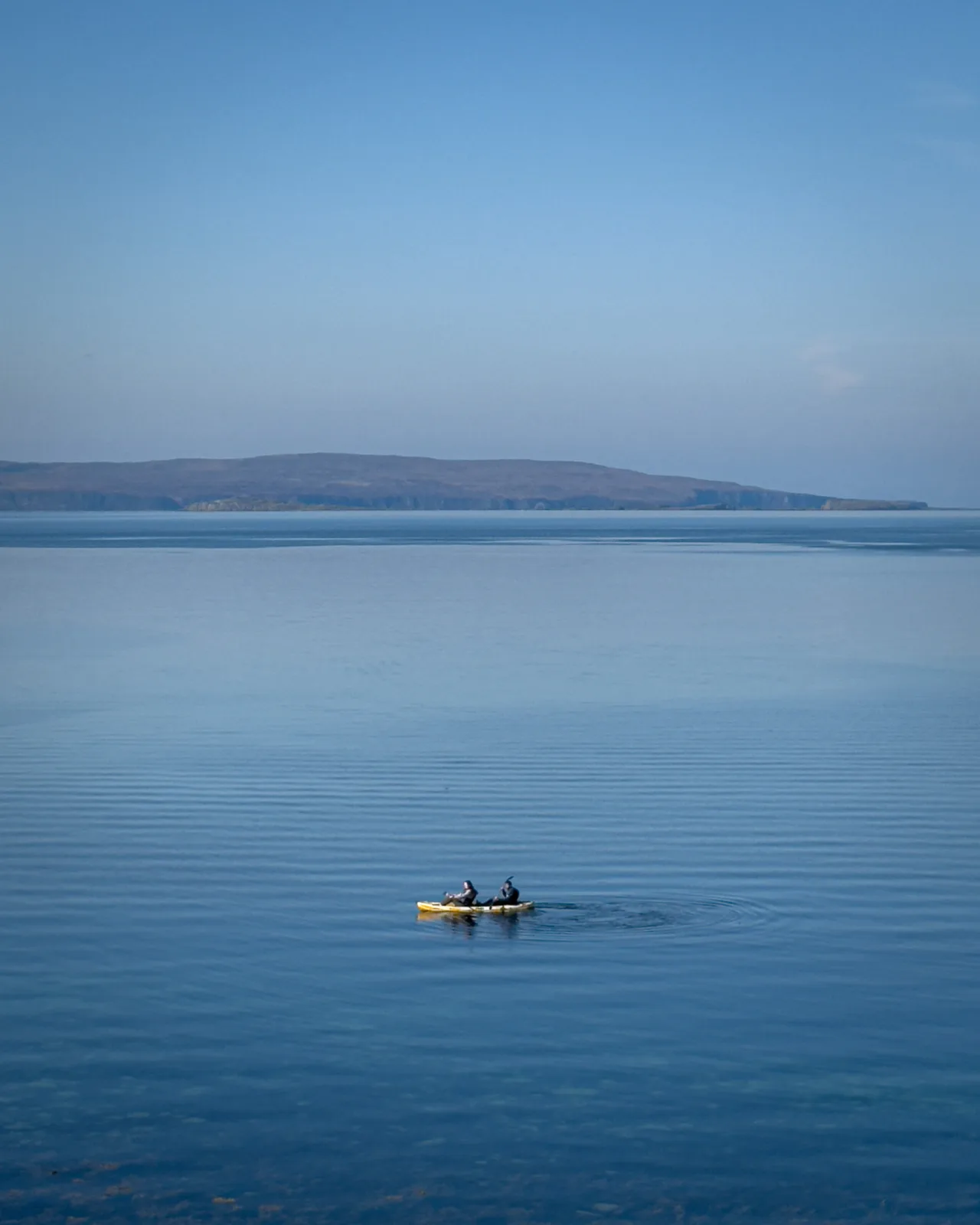 Two people kayaking off the shore of the Isle of Skye