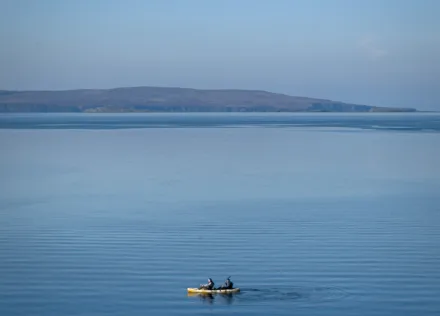 Two people kayaking off the shore of the Isle of Skye