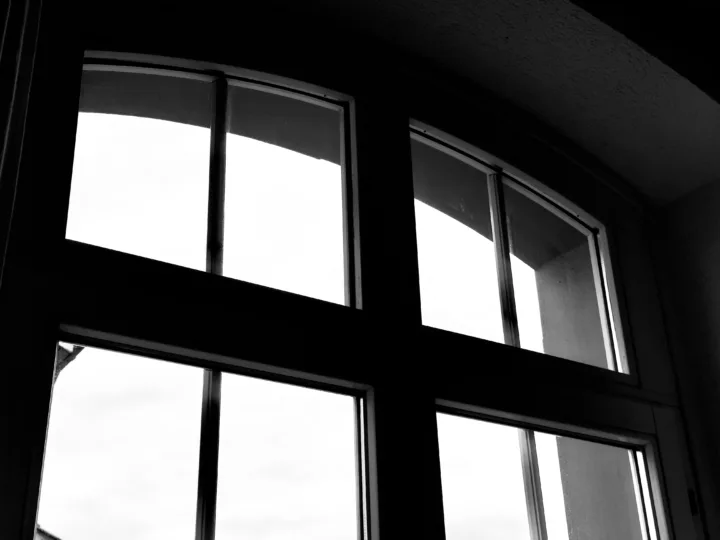 Grey skies viewed through a silhouetted window frame